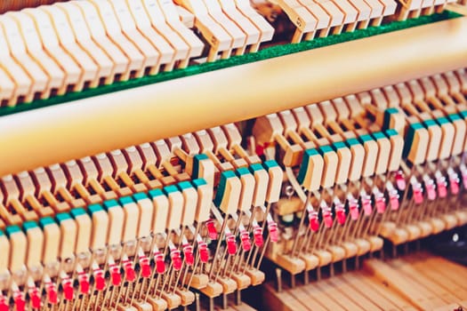 Close-up shallow focus image of the internal mechanisms of an upright piano. It gives a feeling of luxury, beauty, classic, sophistication, elegance. Image can be use for various topics about music.