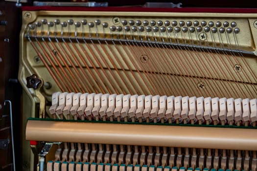 Close-up shallow focus image of the internal mechanisms of an upright piano. It gives a feeling of luxury, beauty, classic, sophistication, elegance. Image can be use for various topics about music.