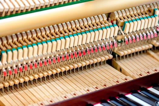 Close-up shallow focus image of the internal mechanisms of an upright piano. It gives a feeling of luxury, beauty, classic, sophistication, elegance. Image can be use for various topics about music.