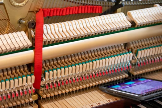 Shallow focus close-up of tools for tuning the internal mechanisms of an upright piano. Gives a feeling of luxury, classic, luxury, grandeur. Pictures can be used on various topics related to music.