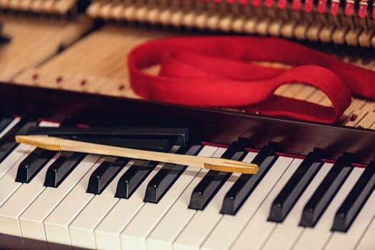 Shallow focus close-up of tools for tuning the internal mechanisms of an upright piano. Gives a feeling of luxury, classic, luxury, grandeur. Pictures can be used on various topics related to music.