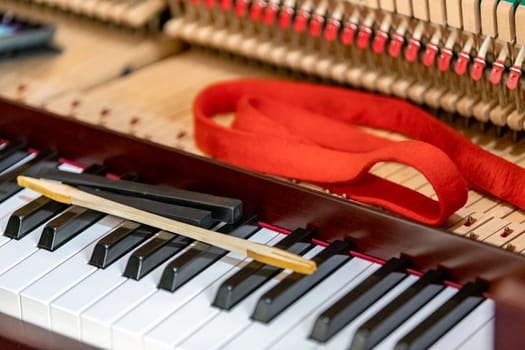 Shallow focus close-up of tools for tuning the internal mechanisms of an upright piano. Gives a feeling of luxury, classic, luxury, grandeur. Pictures can be used on various topics related to music.