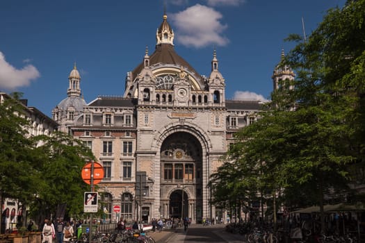 Antwerp, Belgium - June 8th, 2019: The magnificent building of Antwerp Central Station, constructed between 1895 and 1905, shines in the late afternoon sun.