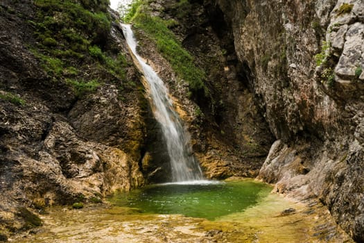 One of the hidden Zapotok waterfalls in upper Trenta Valley in Slovenia, formed by the playful Suhi Potok stream, offers a nice but fresh little swimming pool.