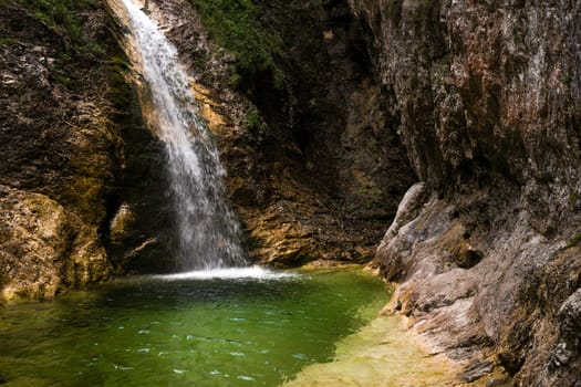 One of the hidden Zapotok waterfalls in upper Trenta Valley in Slovenia, formed by the playful Suhi Potok stream, offers a nice but fresh little swimming pool.