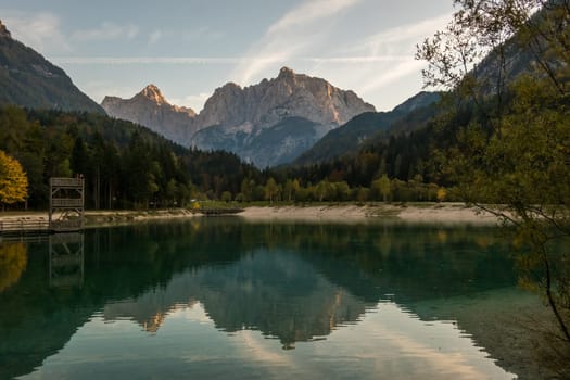 Evening view over the Jasna Lake at Krajnska Gora in Slovenia with the impressive peaks Stenar, Razor und Kriz at the horizon.