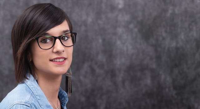 Portrait of a smiling happy woman wearing glasses,a  grey background