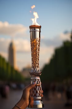 Hand holding a lit torch aloft.