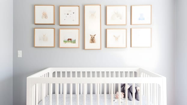Bright white minimalist nursery wall with frames above cradle. Neural network generated in May 2023. Not based on any actual person, scene or pattern.