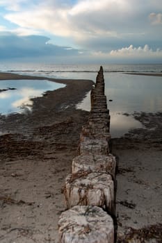 Breakwater on the Baltic Sea coast at low tide with sky and clouds