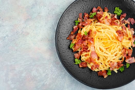 Homemade pasta with fried bacon on a plate, pasta carbonara. Space for text.