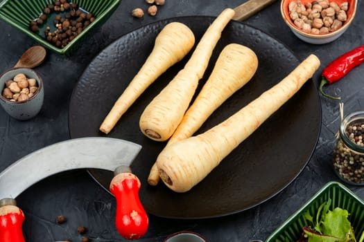 Raw and uncooked whole parsnips roots on the kitchen table