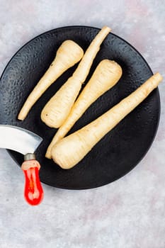 Raw and uncooked whole parsnips roots on the kitchen table
