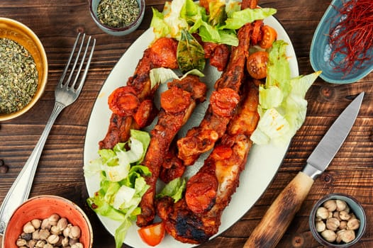 Braised pork ribs in tomato sauce served on a plate.
