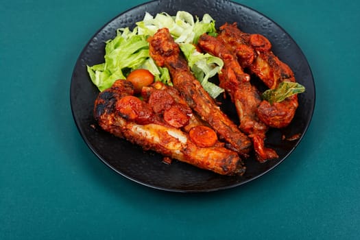 Braised pork ribs in tomato sauce served on a plate.