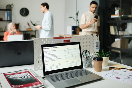 Screen of desktop computer with summary of results standing on workplace of modern broker or economist in coworking space