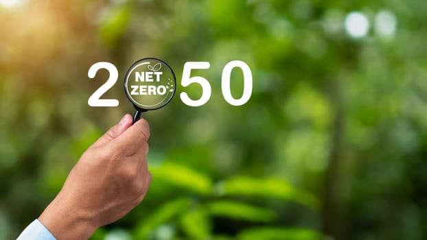 Net zero icon inside magnifier glass, Net zero greenhouse gas emissions target, Carbon neutral and net zero concept, Natural environment Climate-neutral long-term strategy.