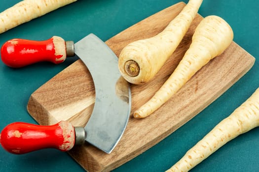 Raw parsnip roots on the kitchen table. Root vegetables. Flat lay.
