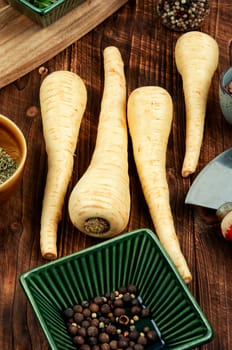 Raw parsnip roots on the kitchen table. Root vegetables. Flat lay.