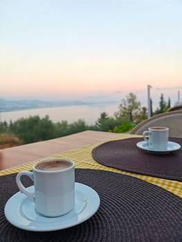 Two white mugs Two white coffee mugs stand on the table against the background of the seaon the table in front of the sea