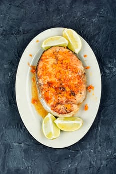 Grilled salmon or trout steak with orange and lime sauce. Space for text.