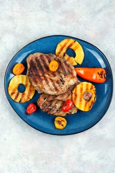 Grilled juicy steak and ananas. Delicious juicy roasted pork steak with pineapple rings.