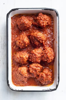 close up of a tray of traditional italian meatballs in tomato sauce