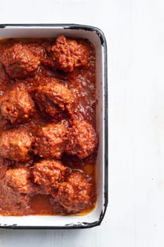 close up of a tray of traditional italian meatballs in tomato sauce