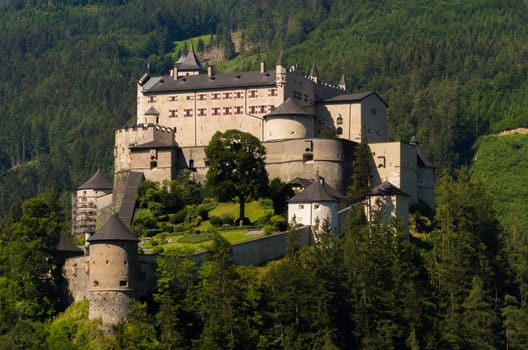 The magnificent medieval Hohenwerfen Castle sitting on a rock shines in the sunlight