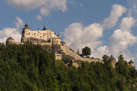 The magnificent medieval Hohenwerfen Castle sitting on a rock shines in the sunlight