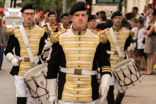 Villach, Austria - Aug. 6, 2022: Musicians in a vintage uniform the procession of 'Villacher Kirchtag', the largest traditional folk festival in Austria, after some years of cancellation due to Covid.