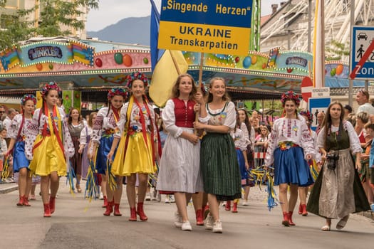 Villach, Austria - August 6, 2022: Girls from Ukraine joining the procession of 'Villacher Kirchtag', the largest traditional folk festival in Austria, after some years of cancellation due to Covid.