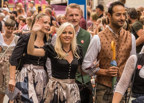 Villach, Austria - August 6, 2022: People enjoy the procession of 'Villacher Kirchtag', the largest traditional folk festival in Austria, after some years of cancellation due to Covid.