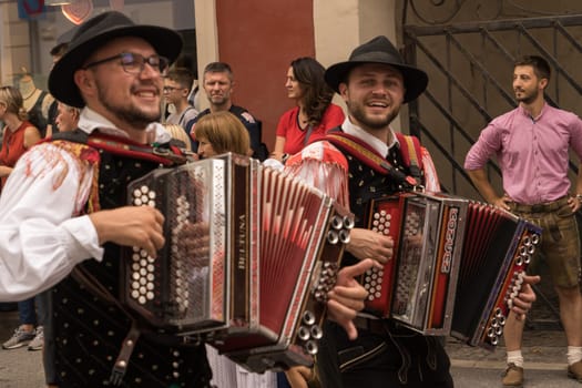 Villach, Austria - August 6, 2022: Musicians enjoy the procession of 'Villacher Kirchtag', the largest traditional folk festival in Austria, after some years of cancellation due to Covid.