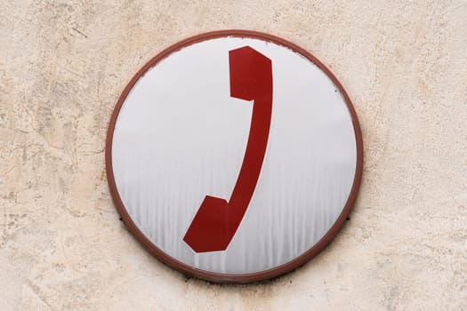 A vintage-style enamel plate illustrating a telephone receiver