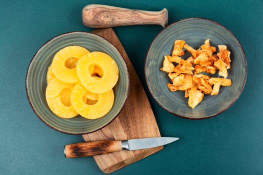 Dry and fresh pineapples in bowls. Candy pineapples, candied fruits. Fruit snack.