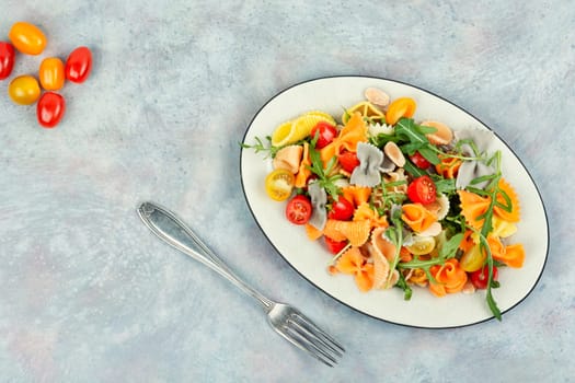 A bowl with traditional pasta salad with fresh tomatoes and herbs. Space for text.