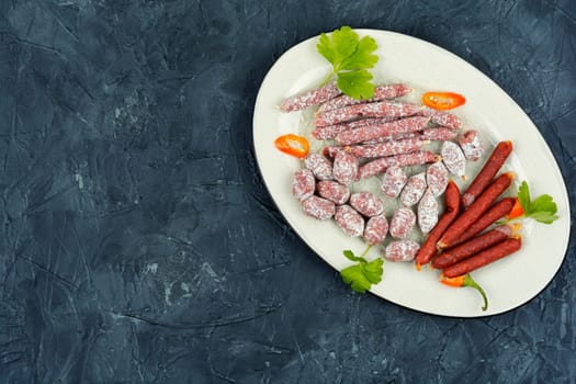 Traditional smoked salami on a plate. Space for text.