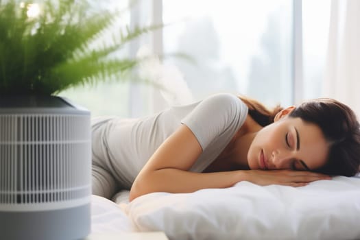 Woman asleep in bed with a focus on the air purifier in the foreground.