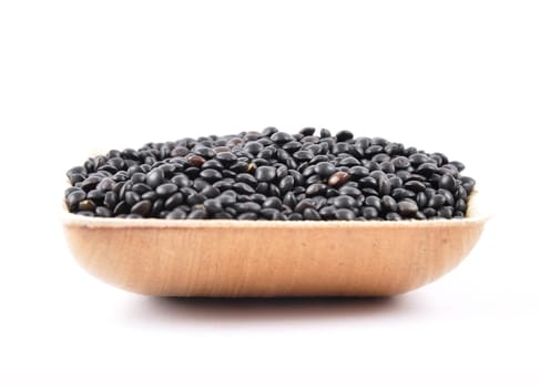 Beluga lentils in bamboo bowl on white background