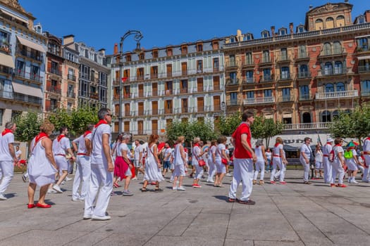 Pamplona, Spain: 09 July 2023: People celebrate San Fermin festival in traditional white abd red clothing with red necktie, Pamplona, Navarra, Spain.