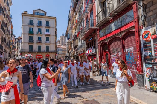 Pamplona, Spain: 09 July 2023: People celebrate San Fermin festival in traditional white abd red clothing with red necktie, Pamplona, Navarra, Spain.