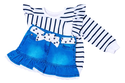 A black and white striped sweater or pullover with a heart and a cute short blue denim skirt with a white fabric belt with flowers and bow isolated. Clipping path.