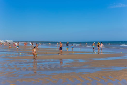 Tavira, Portugal - August 15, 2023: People at the famous beach of Tavira island in Tavira. This beach is a part of famous tourist region of Algarve.