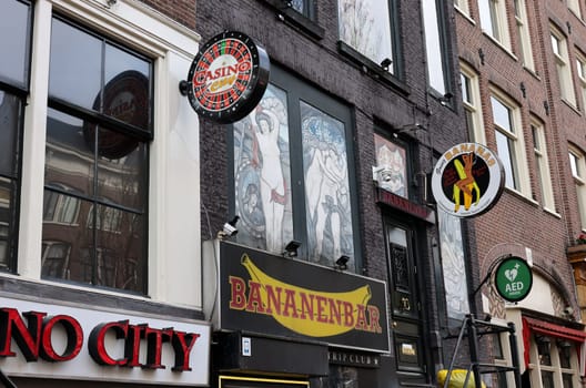 Amsterdam, Netherlands - April 21, 2023: Strip club with live sex shows in De Wallen called the red light district famous for its entertainment character: brothels, coffee shops, pubs and restaurants