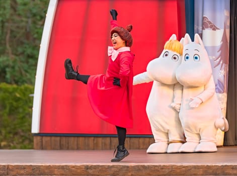 japan, saitama - march 26 2023: The cute Moomintroll and its girlfriend Snorkmaiden looking the Mymble Little My dressed in red with a bun on the head dancing on the stage of the Moominvalley Park.