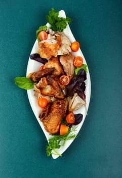 Sliced baked grilled chicken with cherry tomatoes on a plate.