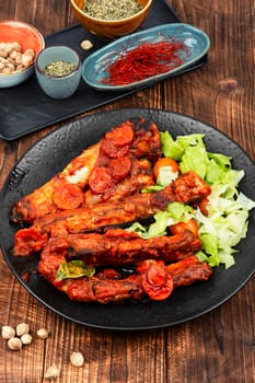 Braised or stewed pork ribs in tomato sauce on old rustic wooden table. Ready for eat.