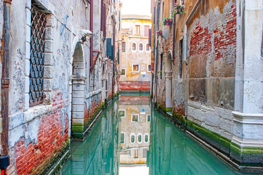 reflectio of old facades in a narrow canal in Venice, Italy.