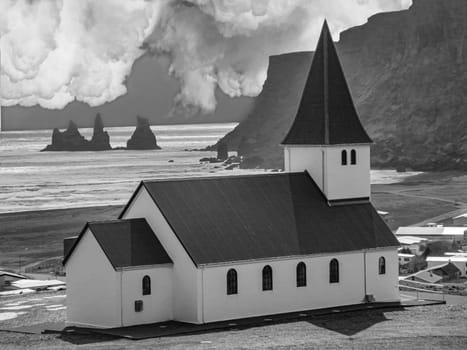 Typical red colored wooden church in Vik town, Iceland in winter. Sunrise light